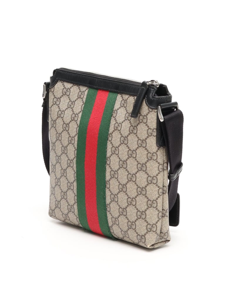 Side view of the vintage Gucci Messenger Bag in beige GG supreme canvas, showing the iconic green and red web stripe.