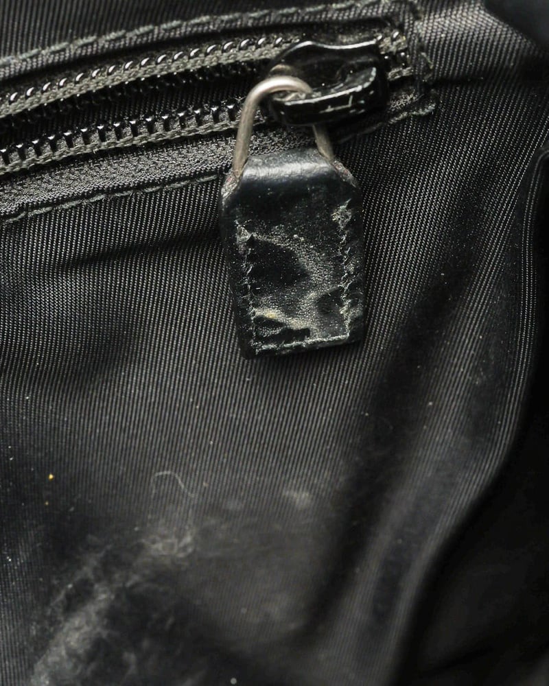 Gucci Messenger Bag interior detail showing peeling on the black leather zipper pull tab.