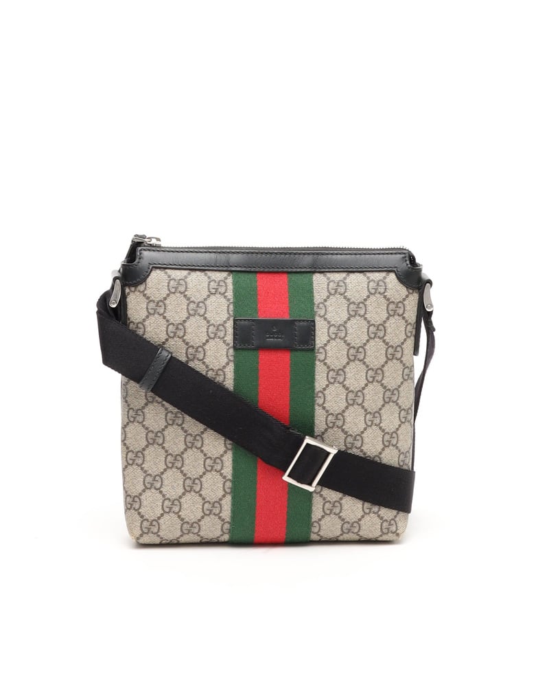 Front view of Gucci Messenger Bag in beige GG Supreme canvas with green and red Web stripe and black strap.