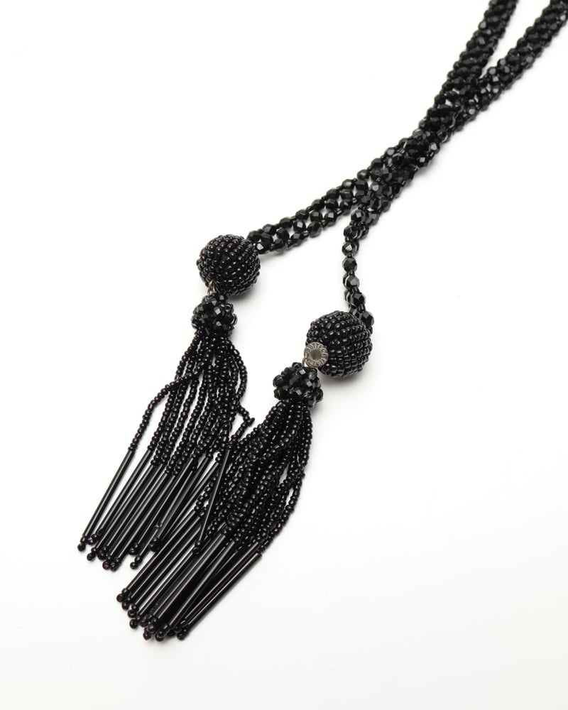 Close-up of the vintage Bottega Veneta tassel necklace, highlighting the intricate black beadwork of the dual tassels.