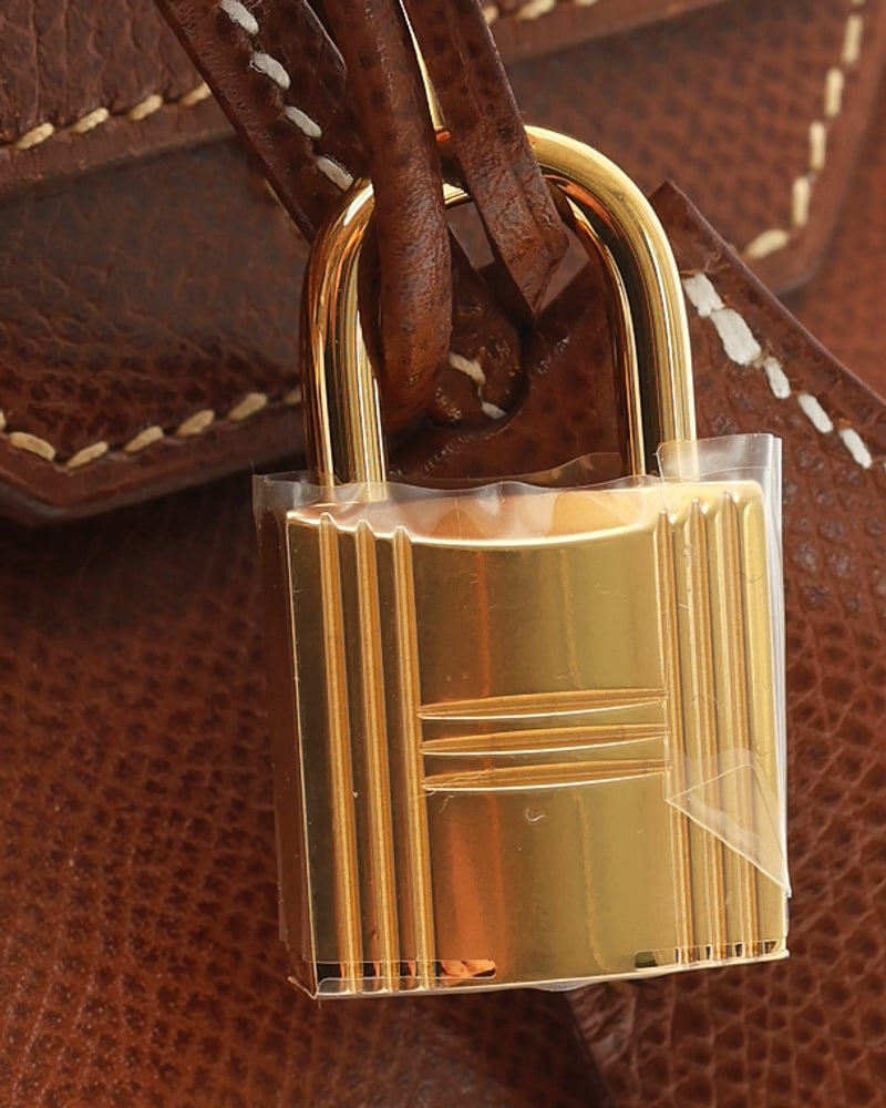 Nahaufnahme des goldenen Schlosses der braunen Hermès Birkin 30 Epsom Tasche, die Hardware und Ledertextur zeigt.