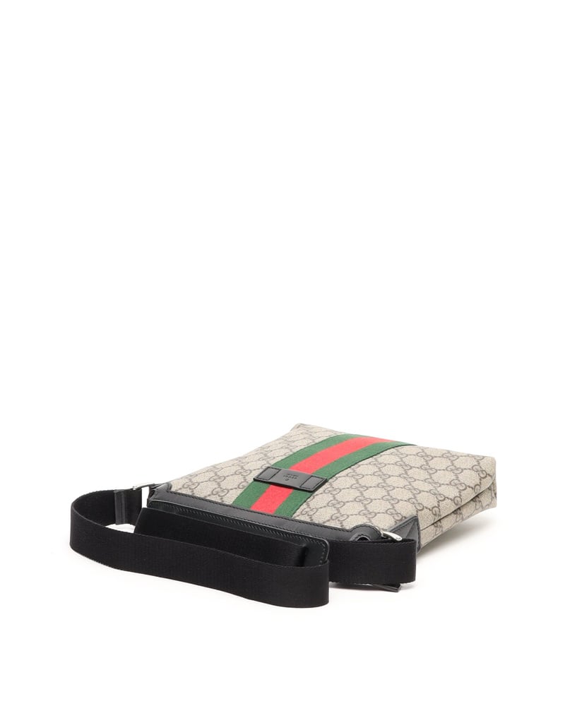 Side profile of a Gucci Messenger Bag in beige GG Supreme canvas with green and red web stripe and black strap.