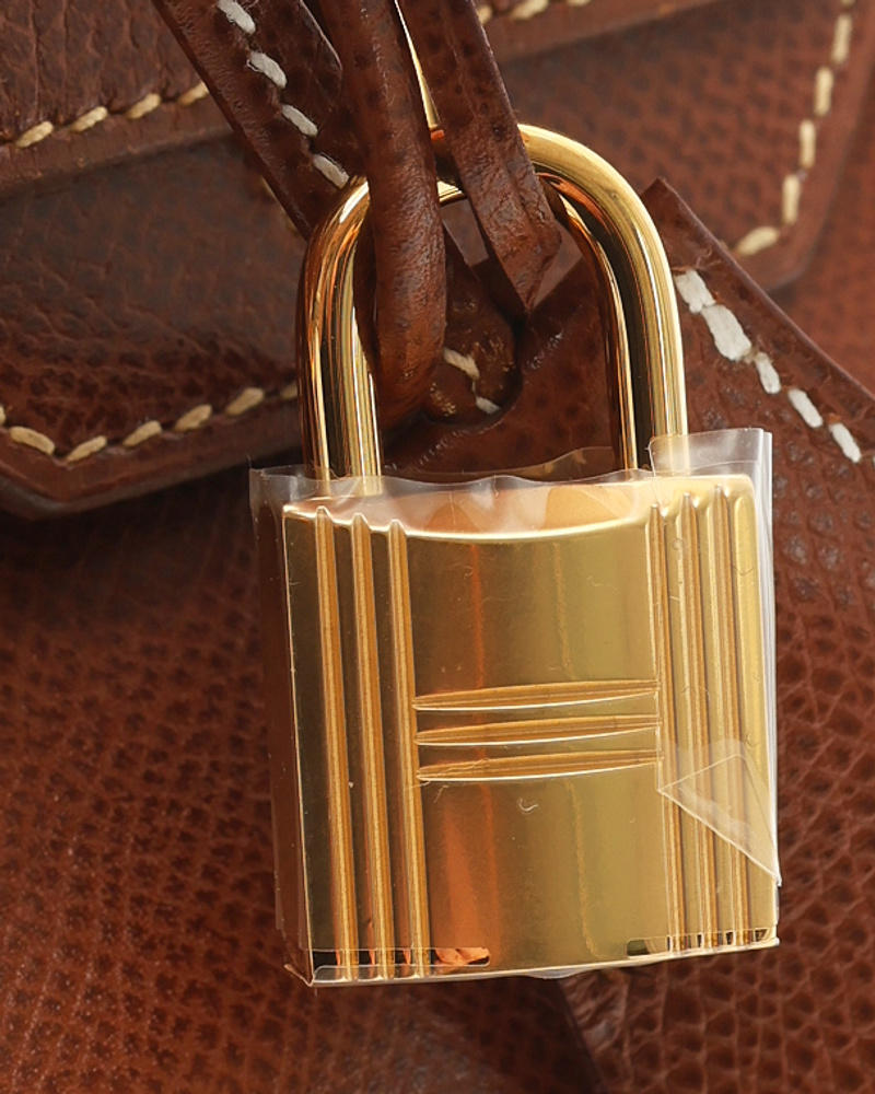 Nahaufnahme des goldenen Schlosses der braunen Hermès Birkin 30 Epsom Tasche, die Hardware und Ledertextur zeigt.