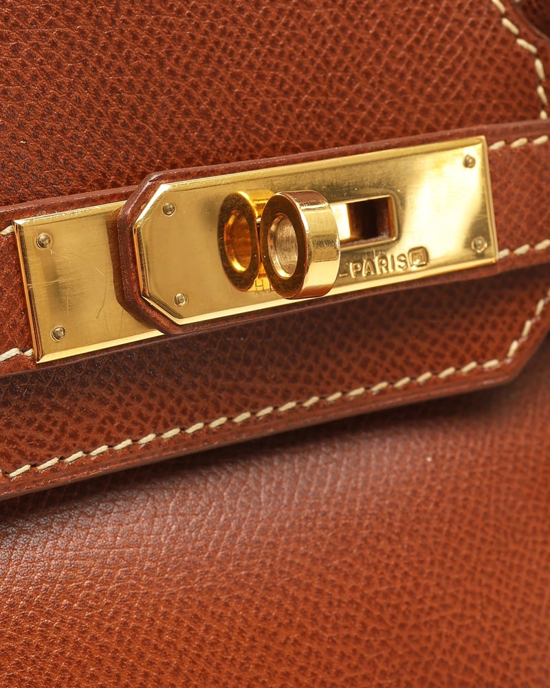 Nahaufnahme der goldfarbenen Hardware und des Drehverschlusses der braunen Hermès Birkin 30 Epsom Tasche.